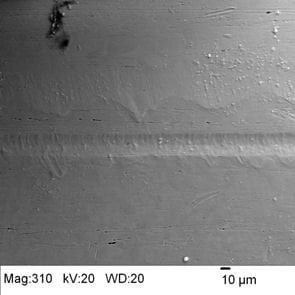 SEM- The Ni wire surface was collected at 310x and shows the relatively smooth surface with a wire drawing line and some elongated pores in the direction of the wire length. 