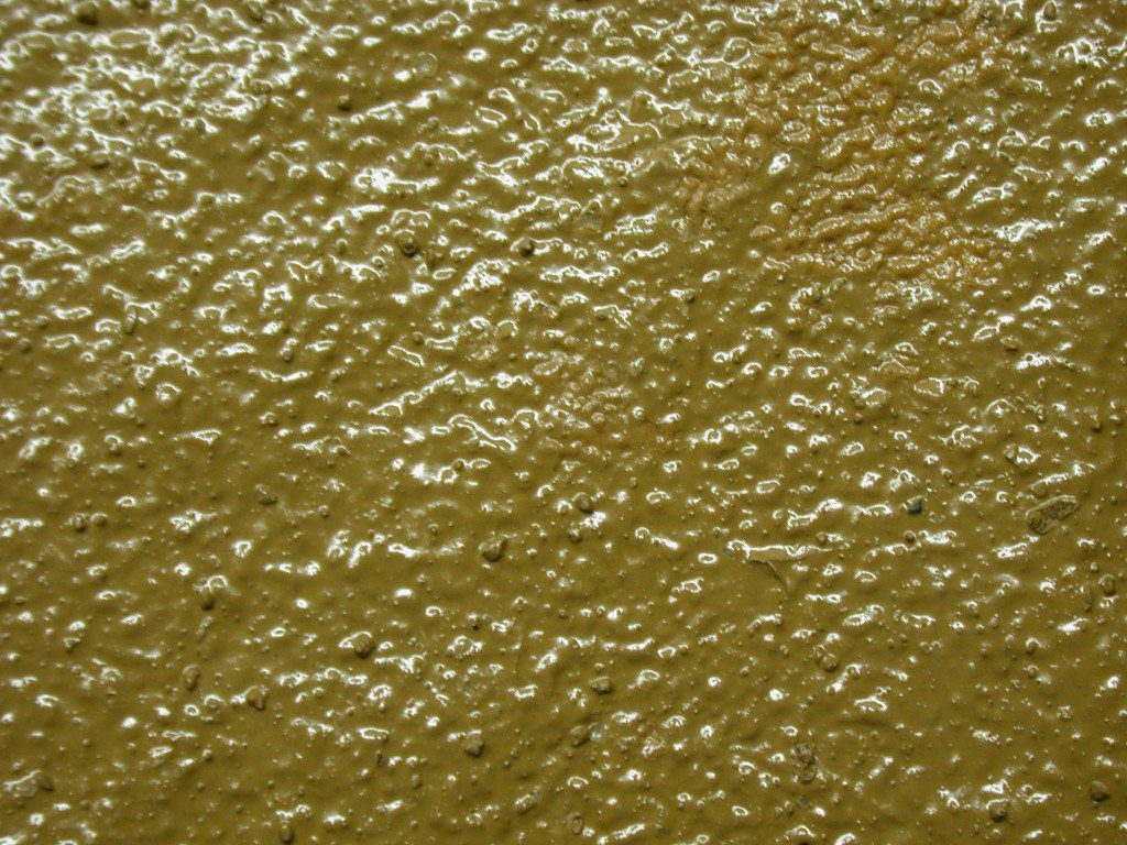 A polyurethane/polyurea polymer UV protection coating with an underlayer thick polyurea/polyurethane coating filled with course ground sand particles to provide a long-range roughness for a high traction surface.