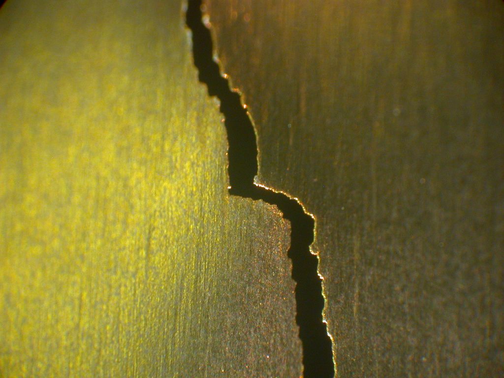 A rupture in a titanium (metal) foil.