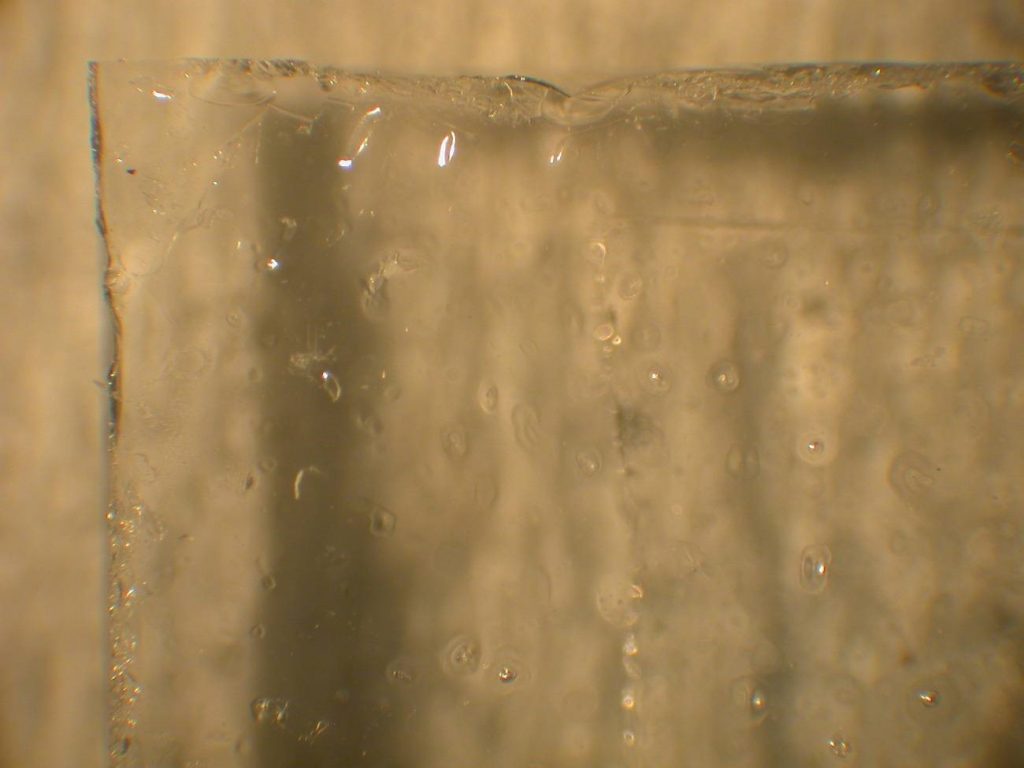 A coating film on a glass surface showing dimpling analyzed for a University.